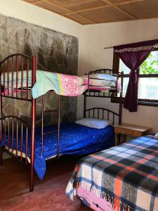 Casa Qatzij - Guest House, Lake Atitlan في San Lucas Tolimán: غرفة نوم بسريرين بطابقين ونافذة