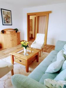 a living room with a blue couch and a coffee table at Pine Crest Ferienwohnung in Harzgerode +29 photos