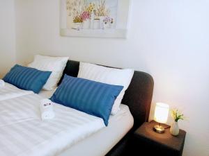 Habitación con sofá y almohadas azules y blancas. en Pine Crest Ferienwohnung, en Harzgerode