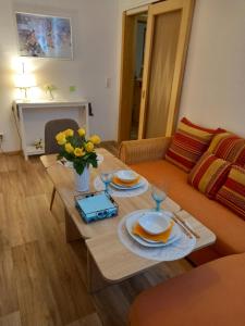 ein Wohnzimmer mit einem Tisch und einem Sofa in der Unterkunft Pine Crest Ferienwohnung in Harzgerode