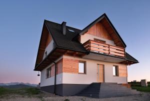 een huis met een gambrel dak bij Domek na Wichrowym Wzgórzu in Dursztyn