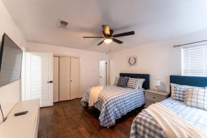 a bedroom with two beds and a ceiling fan at The Magnolia House- One of a kind home in the city in Arlington