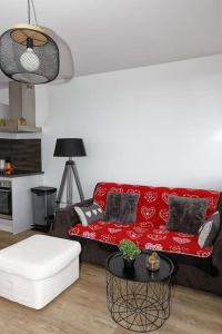 ein Wohnzimmer mit einem roten Sofa und einem Tisch in der Unterkunft Le balcon cerdan in Font Romeu Odeillo Via