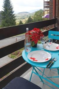 a table with two plates and a bottle and glasses at Le balcon cerdan in Font-Romeu-Odeillo-Via