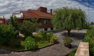 a garden with trees and bushes in front of a house at Quintana 23 in Suances