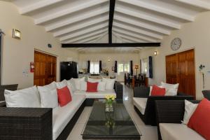 a living room with white couches and red pillows at Villa Swiss Paradise with private pool in Palm-Eagle Beach