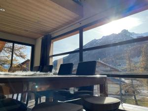 a conference room with a table and chairs and a large window at Appartement spacieux près des pistes in Le Monêtier-les-Bains