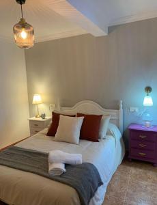 1 dormitorio con 1 cama grande con 2 lámparas y mesita de noche en Casa Hay que Vivir el Momento, en Setenil