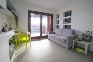 a living room with a couch and a table and a kitchen at Aurum Aparthotels Bicocca in Milan