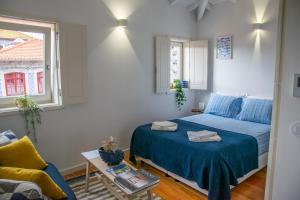 1 dormitorio con cama, sofá y ventana en Olival 54 Apartments, en Oporto