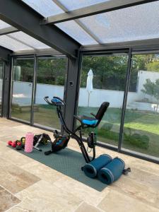 Zimmer mit einem Fitnessraum mit Laufband und Stuhl in der Unterkunft O Bain Soleil in Bourg-Saint-Andéol