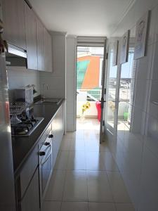 une cuisine avec un évier et une cuisinière dans l'établissement Departamento para 6 personas, à Iquique 2 autres photos