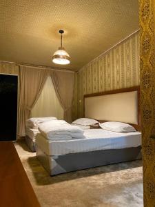 a bedroom with two beds and a chandelier at Almazham hotel room resort in AlUla