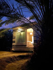 a bed in front of a tiny house at night at Almazham hotel room resort in AlUla