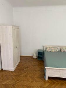 Un dormitorio con una cama y un armario. en Apartament istoric ultracentral - 70 mp - with Parking, en Sibiu