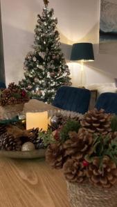 a christmas table with a christmas tree in the background at ROYAL WILLIAM YARD Luxury Apartments at "THE BRUCE" - FAMILY APARTMENT and Connecting DELUXE STUDIO - PRIVATE connecting lobby so BOOK BOTH For LARGER GROUPS - FREE ONSITE PARKING in Plymouth