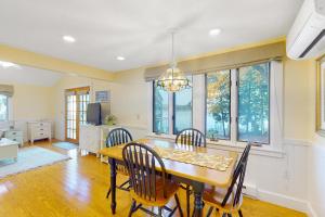 a dining room with a table and chairs and windows at Stoneybrook Retreat Haven - The Cottage in State Landing