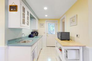 a kitchen with a sink and a tv on a counter at Stoneybrook Retreat Haven - The Cottage in State Landing