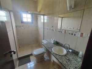 a bathroom with a toilet and a sink and a shower at Hostel Ares do Mundo in Miguel Pereira