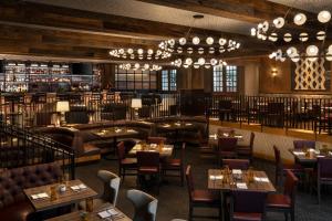 a restaurant with tables and chairs and chandeliers at Omni La Mansion del Rio in San Antonio