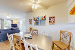 a dining room and living room with a table and chairs at Villas on the Gulf H10 in Pensacola Beach