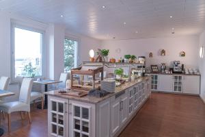 ドルトムントにあるNP Hotel Königshofの白いキャビネット、テーブルと椅子付きのキッチンが備わります。