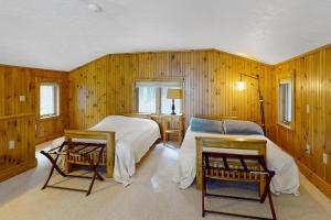 a bedroom with two beds and two chairs in it at Stoneybrook Retreat Haven - The Carriage House in State Landing