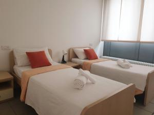 a room with three beds and a couch at Apparthotel CASA IDEALE LECCO in Lecco