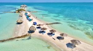 an aerial view of a beach with umbrellas and the ocean at Hostal del Mar - Tolu in Tolú