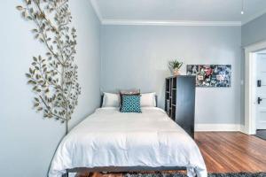 una camera da letto con un letto con un murale di un albero sul muro di Unwind and Relax in a Historic Midtown Property a Memphis