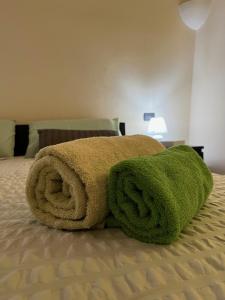 zielony ręcznik na łóżku w sypialni w obiekcie Saint Michel Apartment w mieście Dolceacqua
