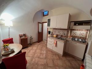 a kitchen with white cabinets and a table in a room at Saint Michel Apartment in Dolceacqua