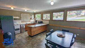a kitchen with a table and a table and chairs at Nettin View 4 in Jindabyne