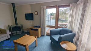 a living room with a couch and a chair and a table at Nettin View 4 in Jindabyne