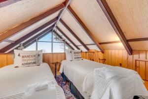 two beds in a room with a window at West Wind in Beech Mountain