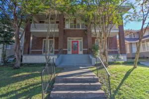 a brick house with a red door and stairs at 1900's Historic Getaway - Prime Midtown Location! in Memphis