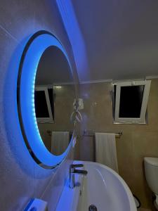 ein Badezimmer mit einem Spiegel, einer Badewanne und einem Waschbecken in der Unterkunft Old Town Inn in Pogradec