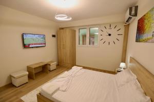 ein Schlafzimmer mit einem Bett und einer Uhr an der Wand in der Unterkunft Old Town Inn in Pogradec + 41 Fotos