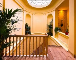 a hallway with a wooden staircase with plants at Appartement spacieux & calme avec vue sur l'Escaut in Tournai