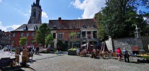 a group of people sitting in chairs in front of a building at Appartement spacieux & calme avec vue sur l'Escaut in Tournai