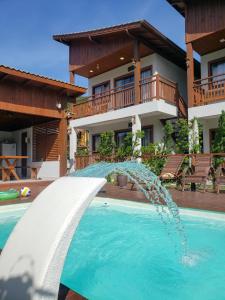 a water fountain in a pool in front of a house at Pousada Rosa Maria in Praia do Rosa