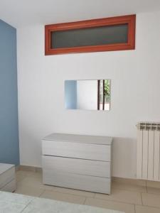 a bathroom with a white dresser and a mirror at Appartamenti Casa Sofia in Castello di Cisterna