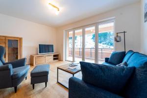 ein Wohnzimmer mit einem blauen Sofa und einem TV in der Unterkunft Ferienwohnung Feldberg Schwarzwald in Feldberg