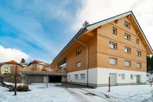 ein großes Gebäude mit Balkon im Schnee in der Unterkunft Ferienwohnung Feldberg Schwarzwald in Feldberg