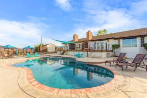 a swimming pool with chairs and a building at Villa Inn- Adults Only- Temecula Wine Country in Temecula
