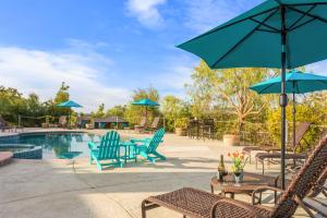 a patio with chairs and umbrellas and a pool at Villa Inn- Adults Only- Temecula Wine Country in Temecula