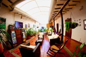 a living room filled with lots of furniture and plants at Real Dream Hostel in San Gil