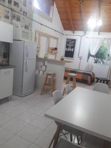 una cocina con electrodomésticos blancos, mesa y sillas en Penny lane en San Carlos de Bariloche