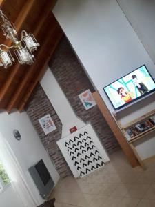 a living room with a tv and a brick wall at Penny lane in San Carlos de Bariloche