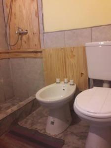 y baño con aseo blanco y lavamanos. en Penny lane en San Carlos de Bariloche